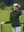 The model is wearing Women's Water-Resistant Stretch Fleece Lined Jacket forest green on the golf course.