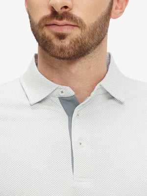 Close-up of a model wearing the grey white feather weight jacquard polo shirts, focusing on the collar and face