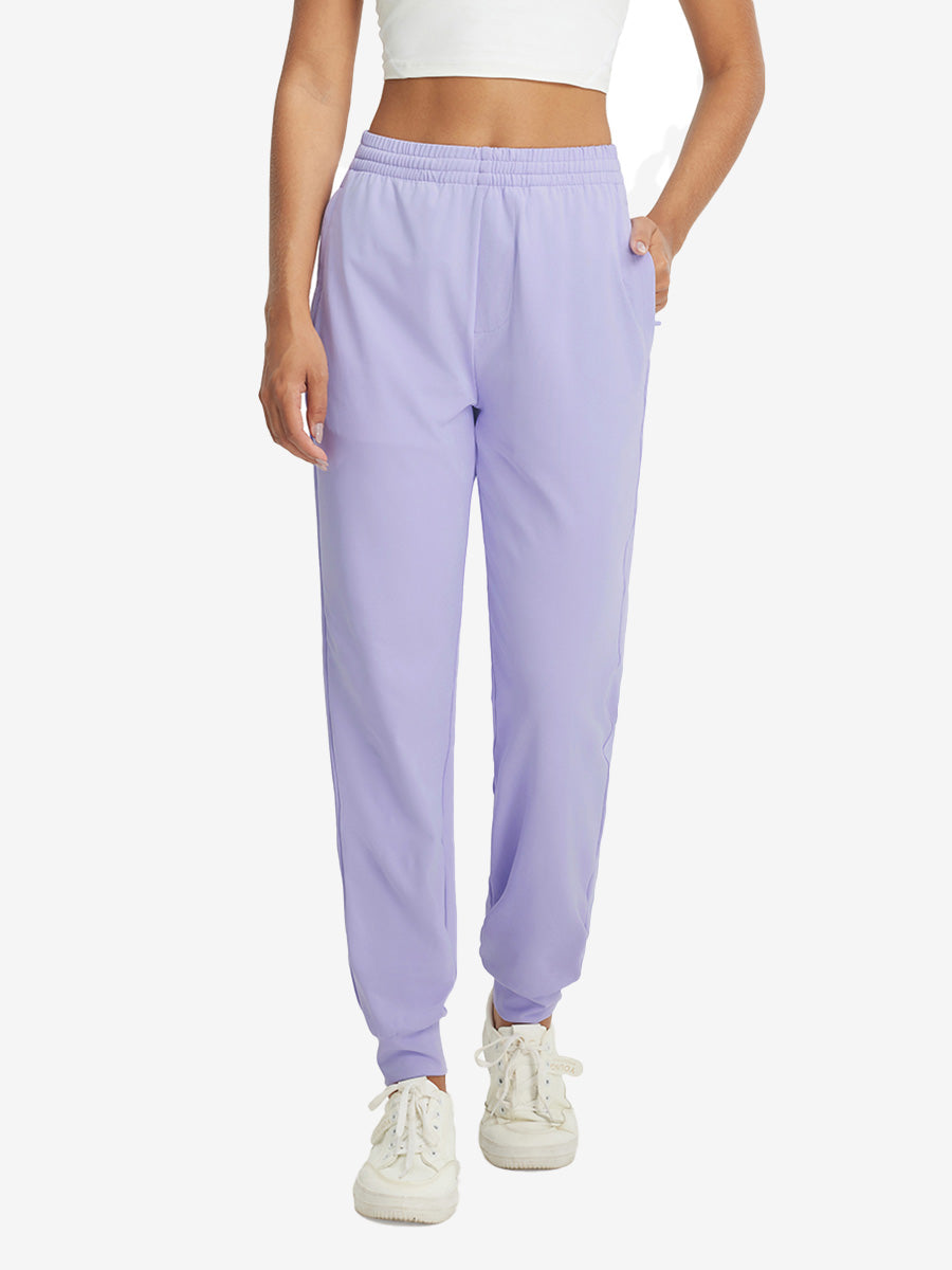 Model with hand in pocket wearing lightweight women's stretchy joggers sweatpants in lavender purple.
