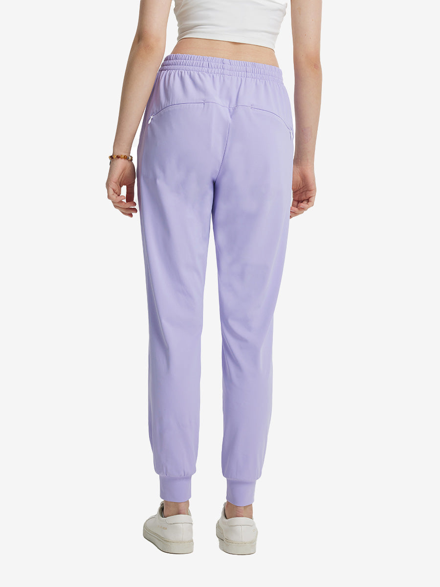 Back view of lightweight women's stretchy joggers sweatpants on model, shown in lavender purple.