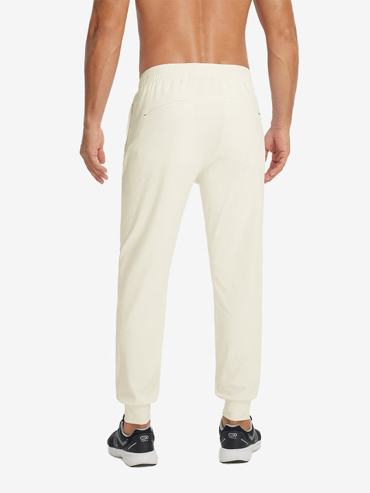Back lower-body view showing lightweight traning track pants on model in cream.