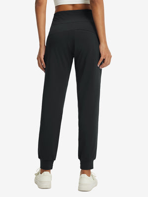 Model wearing women's stretch fleece lined water resistant joggers in black, showing the back lower body view.