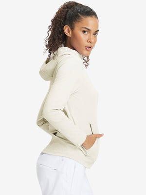 Model with one hand in side pocket wearing women's lightweight hoodies pullover in cream.