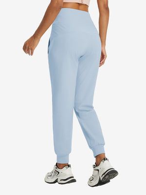 Model wearing women's stretch fleece lined water resistant joggers in light grayish blue, showing the back lower body view.