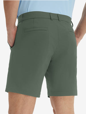 Back lower body view of model wearing the grey green stretch soft flat front dress golf shorts, highlighting the rear design