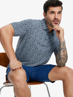 Seated view of model on chair wearing GRAYISH BLUE FLOWER Popular Heather Print Polo showing fit and style