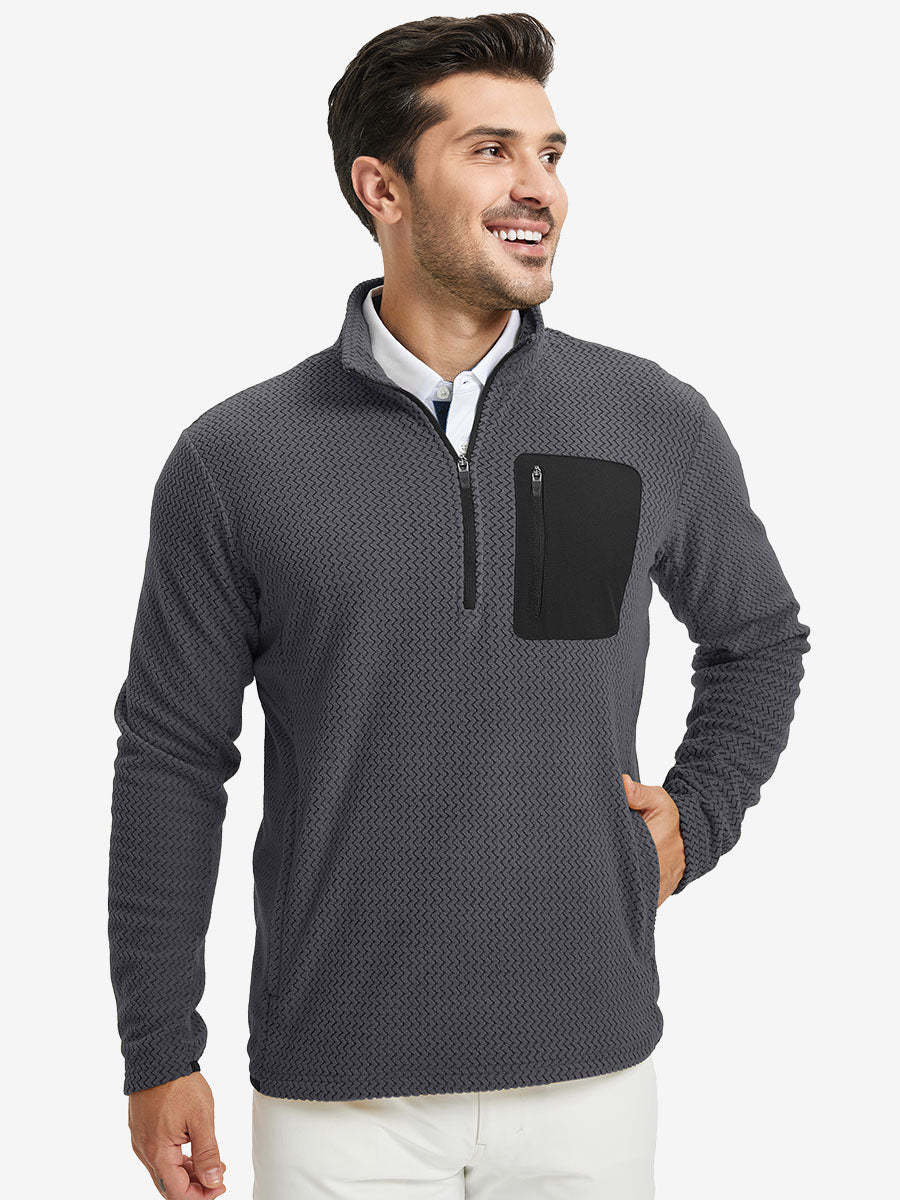 Model with one hand in side pocket, wearing midweight warm stretchy quarter zip pullover in grey.