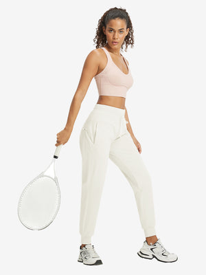 Full-body front view of model wearing women's stretch fleece lined water resistant joggers in beige.