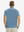 Back half-body view of model wearing the misty blue ventilated pique performance polo, highlighting the rear silhouette