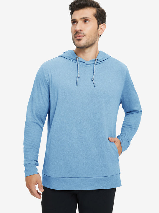 Model with one hand in pocket, wearing classic heather pullover hoodie in light blue melange, relaxed look.