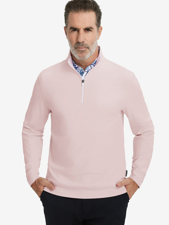 Front upper body view of model wearing lightweight golf quarter zip pullover in light pink, relaxed fit.