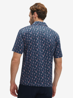 Back half-body view of model wearing the navy sailboat 4 way stretch print collared polo shirt, highlighting the rear silhouette