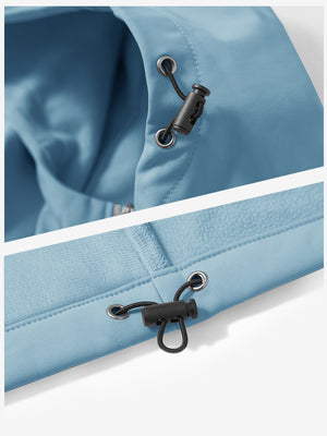 Close-up of zipper and button details on reflective hooded softshell jacket in misty blue.