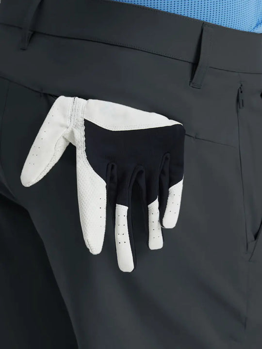 Back view of Player Fit Versatile Solid Shorts 7 Inch with golf glove tucked into right pocket – DARK GREY