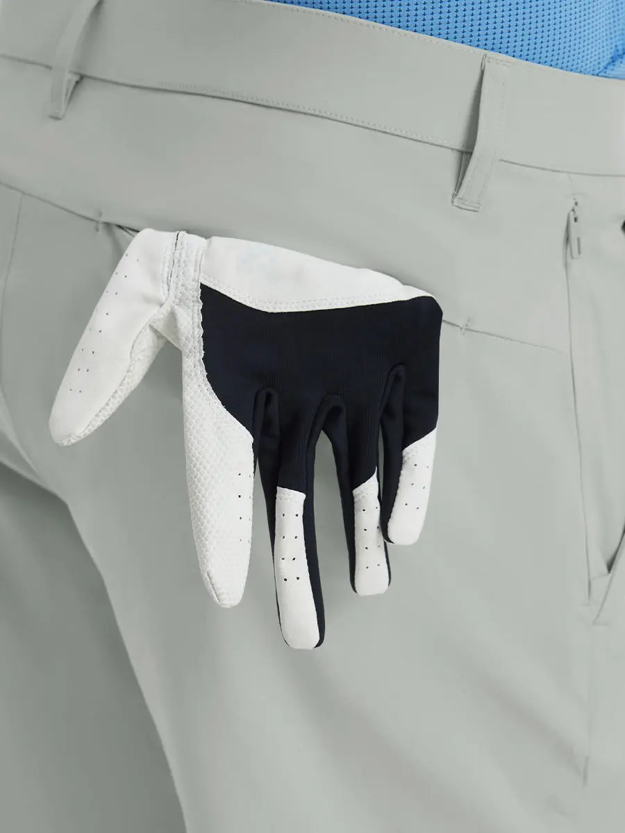 Back view of Player Fit Versatile Solid Shorts 7 Inch with golf glove tucked into right pocket – NEUTRAL GREY