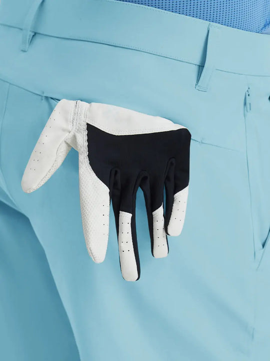 Back view of Player Fit Versatile Solid Shorts 7 Inch with golf glove tucked into right pocket – LIGHT BLUE