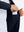 Hand placing iPhone into inner pocket of lightweight water-resistant outerwear jacket in navy