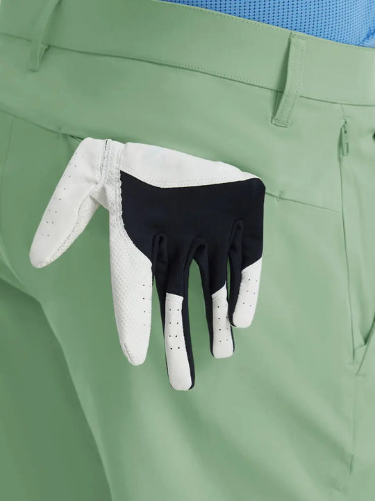 Back view of Player Fit Versatile Solid Shorts 7 Inch with golf glove tucked into right pocket – BERYL GREEN