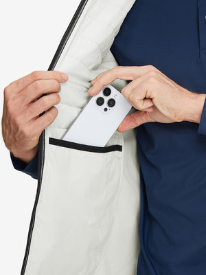 Inner pocket detail of Lightweight Water Resistant Puffer Vest in white, holding smartphone