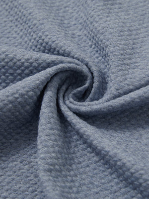 Close-up of fabric on textured insulated winter jacket, showing texture and finish in blue heather.