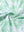 Close-up of light green leaf performance jersey print polo fabric showing breathable texture.