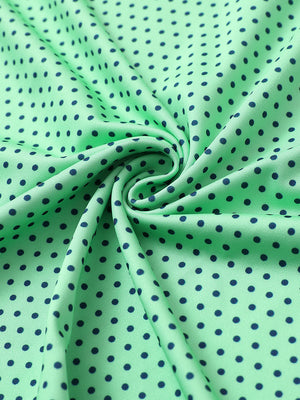 Close-up of green navy dot performance jersey print polo fabric showing breathable texture.