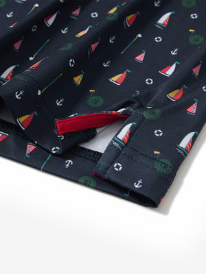 Close-up of the hem vent on the colorful sailboat 4 way stretch print collared polo shirt, showing the side split for movement