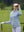 The model is wearing Women's Water-Resistant Stretch Fleece Lined Jacket light grayish blue on the golf course.