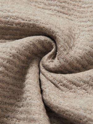 Close-up fabric detail of soft sweatpants with 4 zipper pockets, smooth texture and cozy light brown heather feel