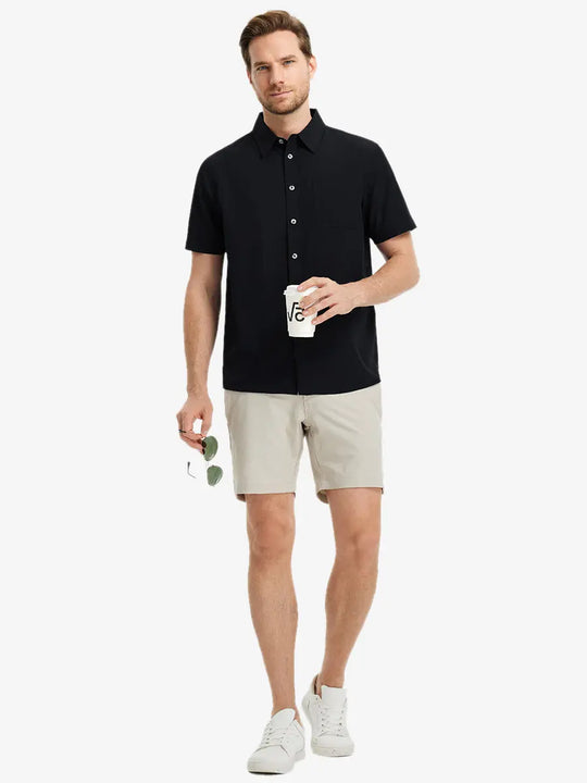 Detail shot with model holding a takeaway drink and sunglasses, featuring the BLACK polo’s side vent.