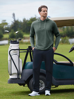 Model in green heather classic heather fleece hoodies standing in front of a golf cart on the course